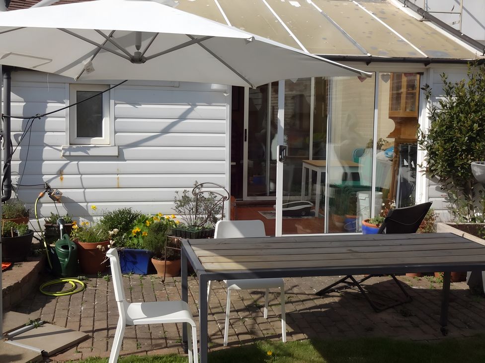 A garden with a table and chairs and potted plants at 55 Egerton Road