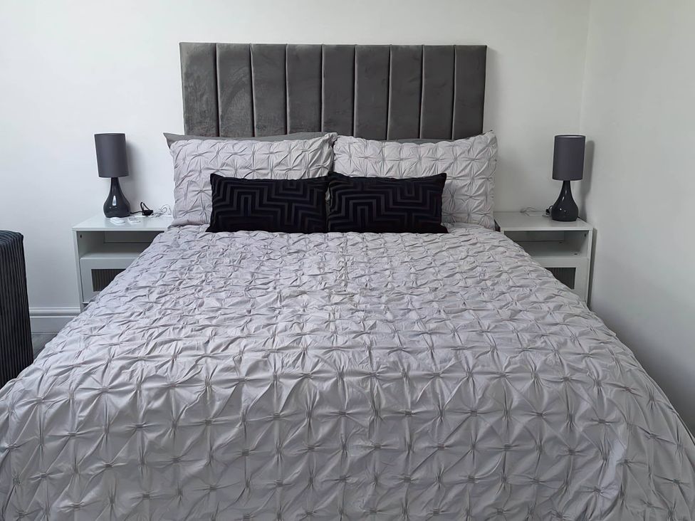 A bedroom with a bed and bedside tables at the property