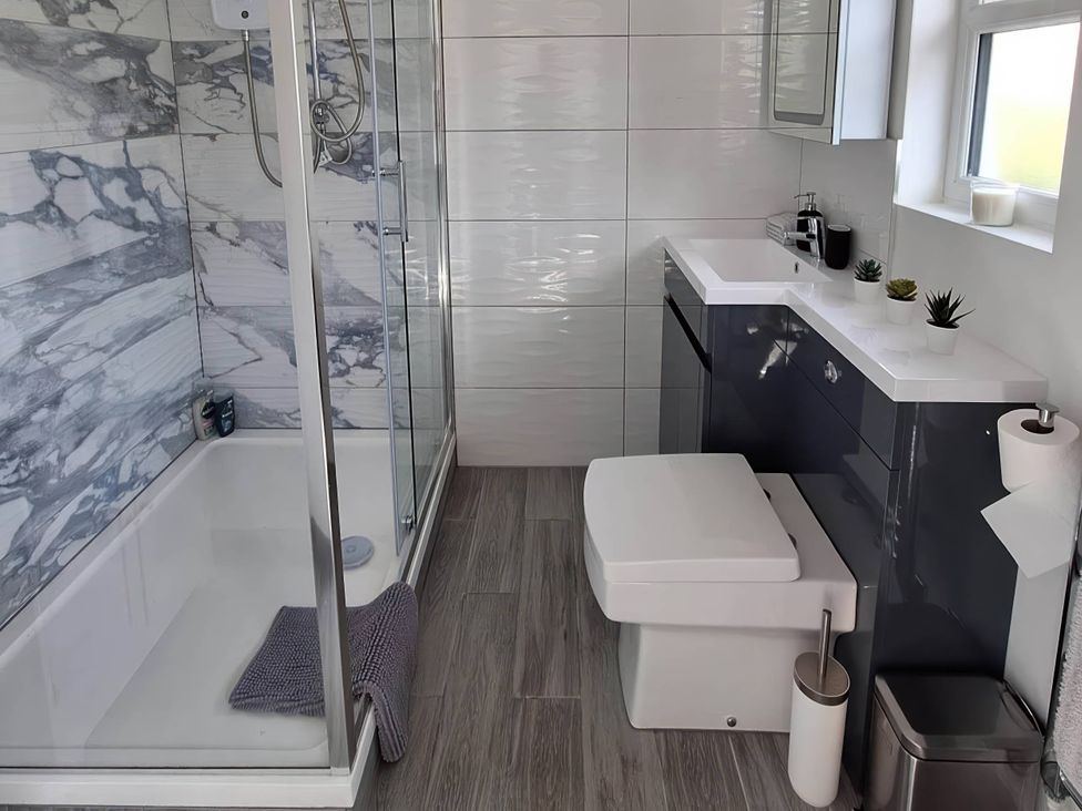 A bathroom with a shower, toilet, and sink at The Old Barn in Manchester