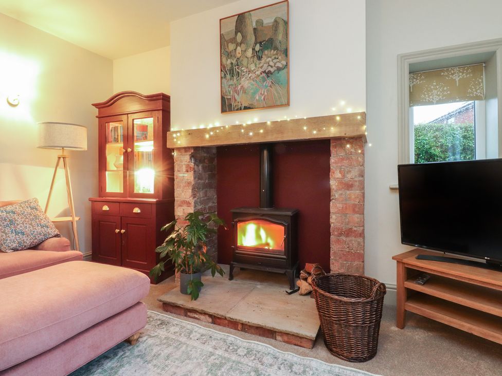 A living room with a fireplace and television at Levenside Preston