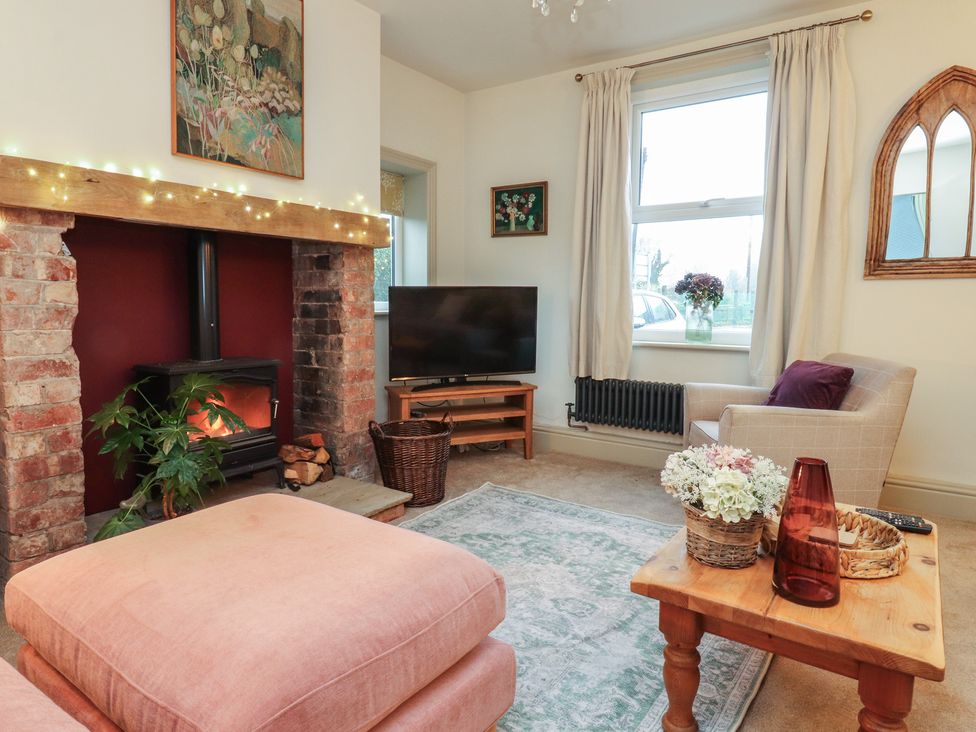 A living room with a fireplace and television at Levenside Preston