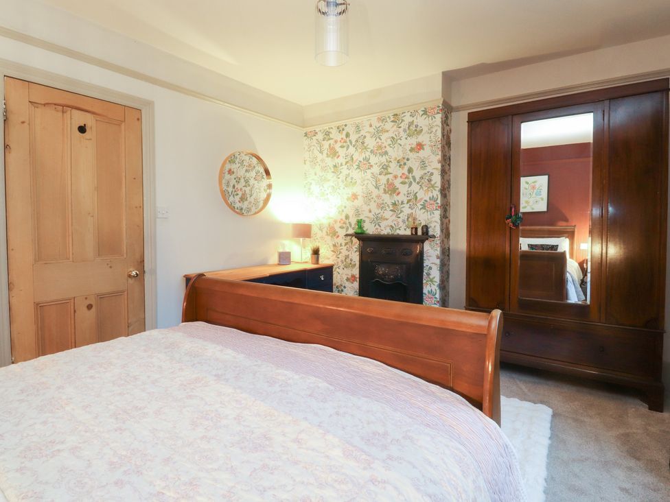 A bedroom with a bed, mirror, and dresser at Levenside in Preston