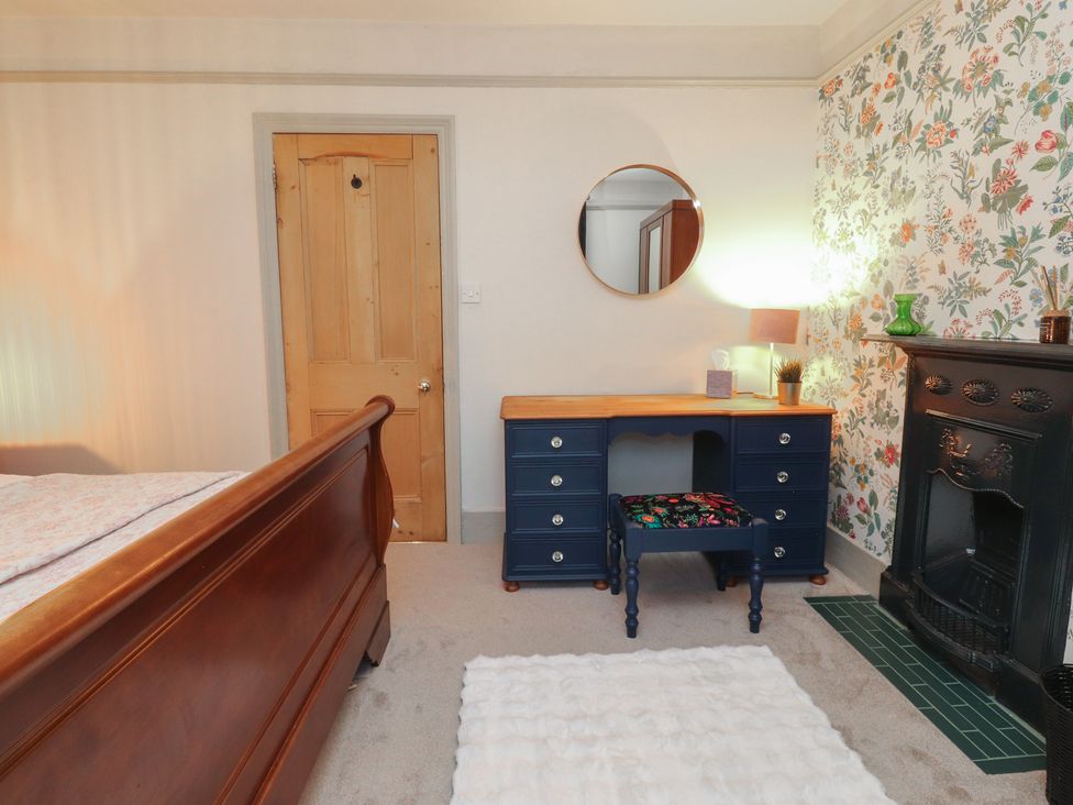 A bedroom with a bed, desk, and fireplace at Levenside in Preston