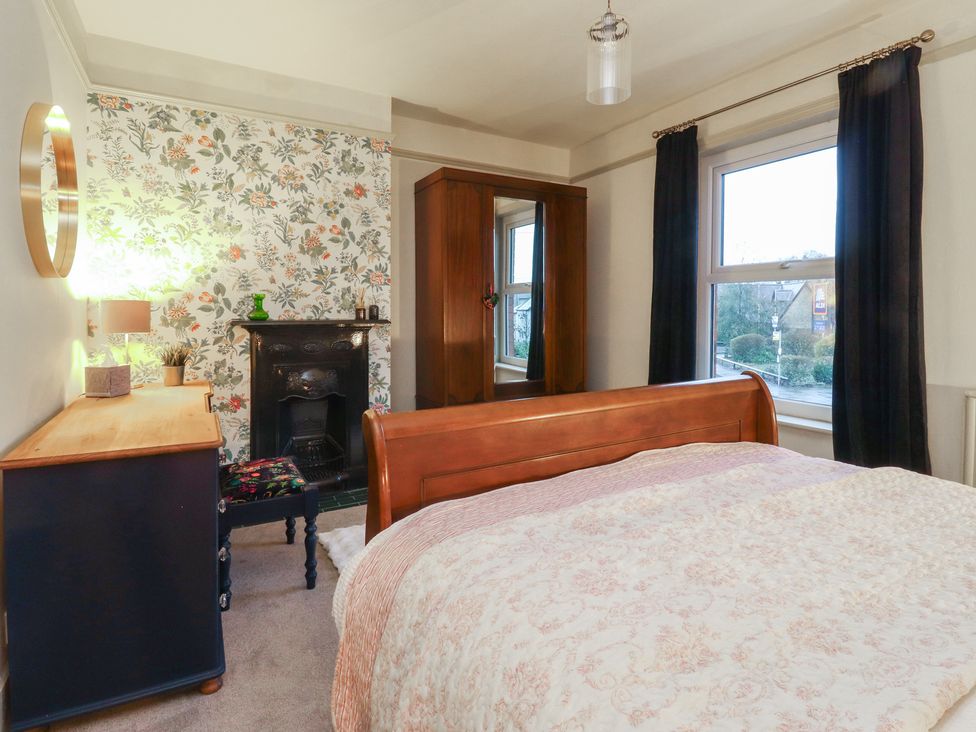 A bedroom with a bed, dresser and lamp at Levenside in Preston