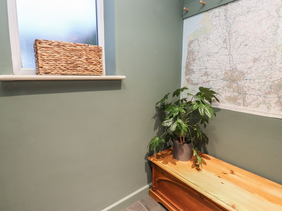 An entrance with a bench, a plant, a basket, and a map at Levenside in Preston