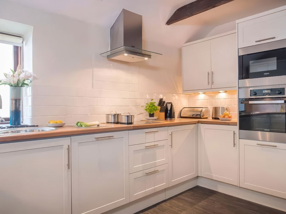 A kitchen with appliances and counter at The Granary, Engollan near St Merryn