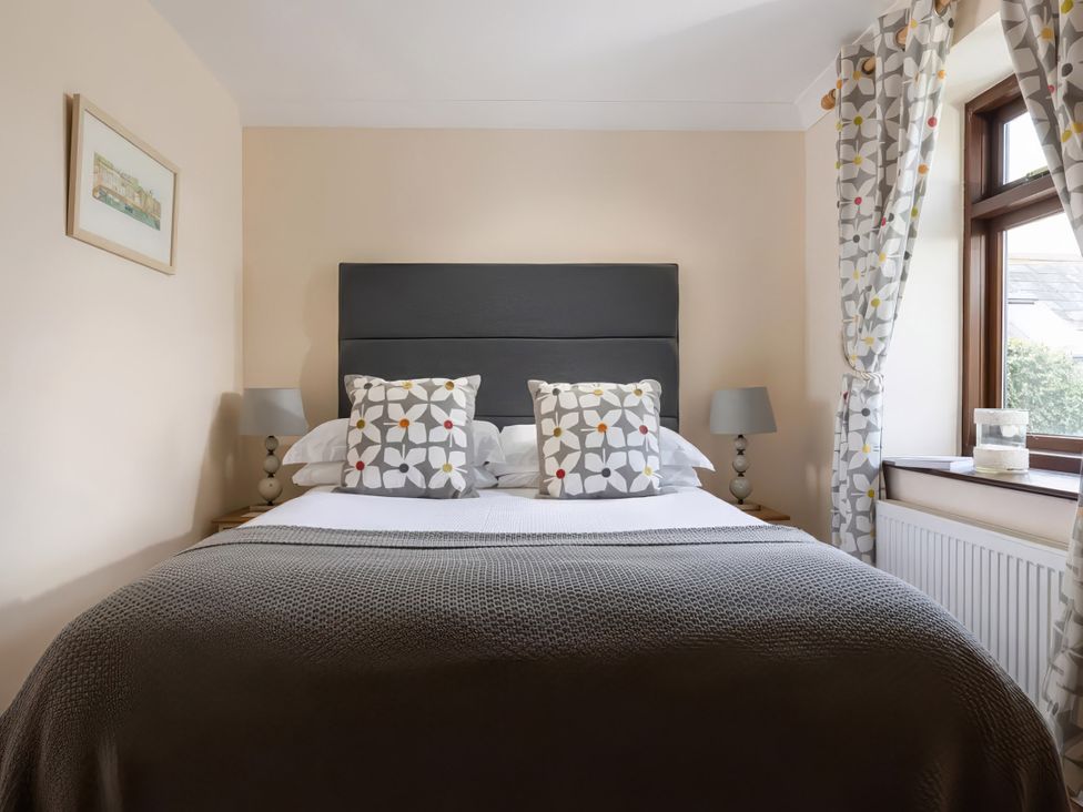 A bedroom with a bed and decorative pillows at The Granary, Engollan near St Merryn