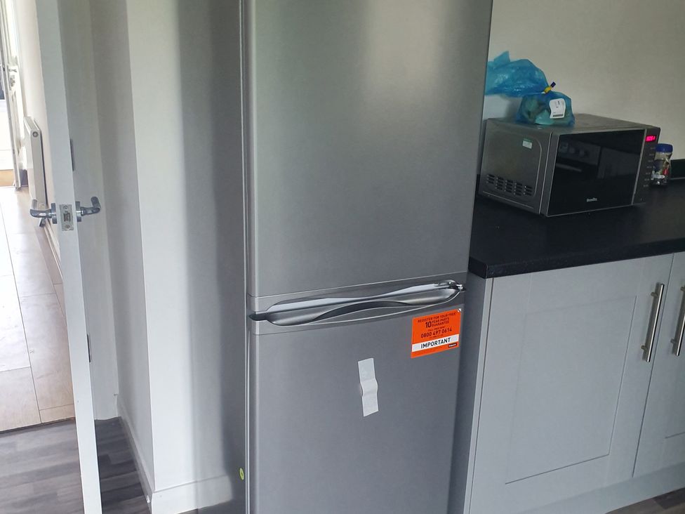 A refrigerator and microwave on a kitchen counter