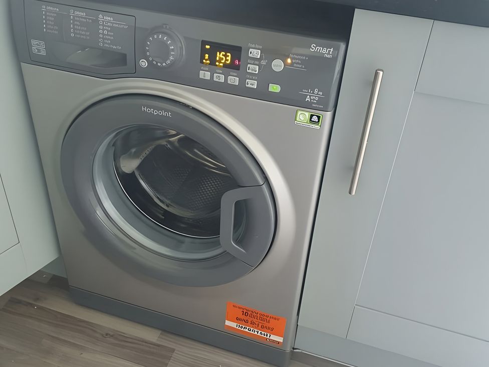 A washing machine with control panel in a laundry room