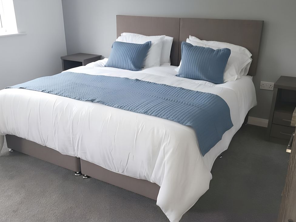 A bed with blue and white bedding in a bedroom