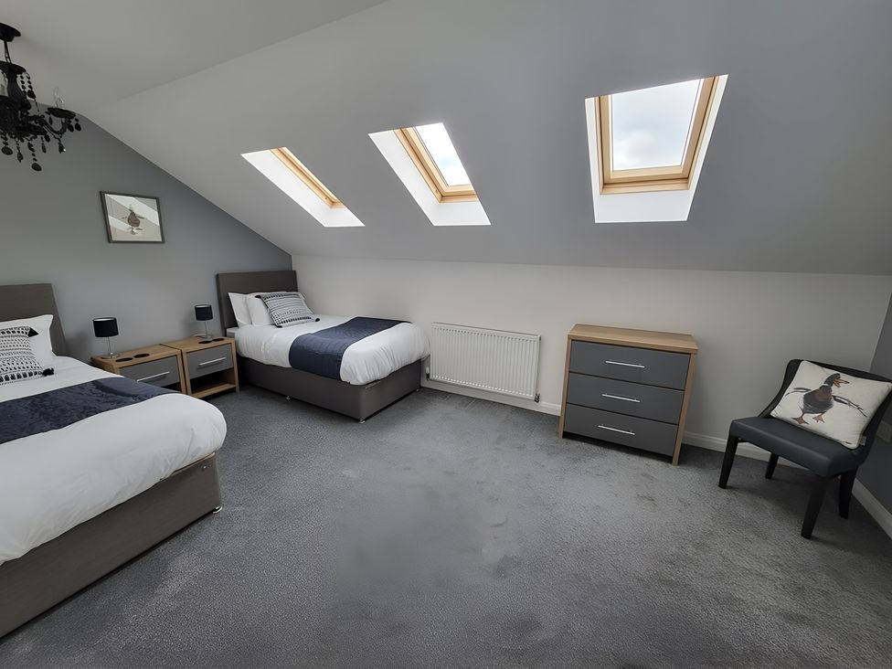 A bedroom with two beds and a chest of drawers at the property