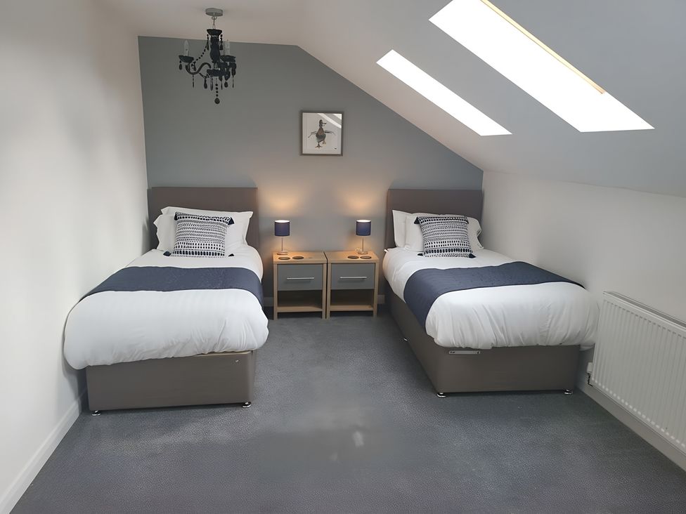 A bedroom with two beds and bedside tables at The Old Barn in Manchester