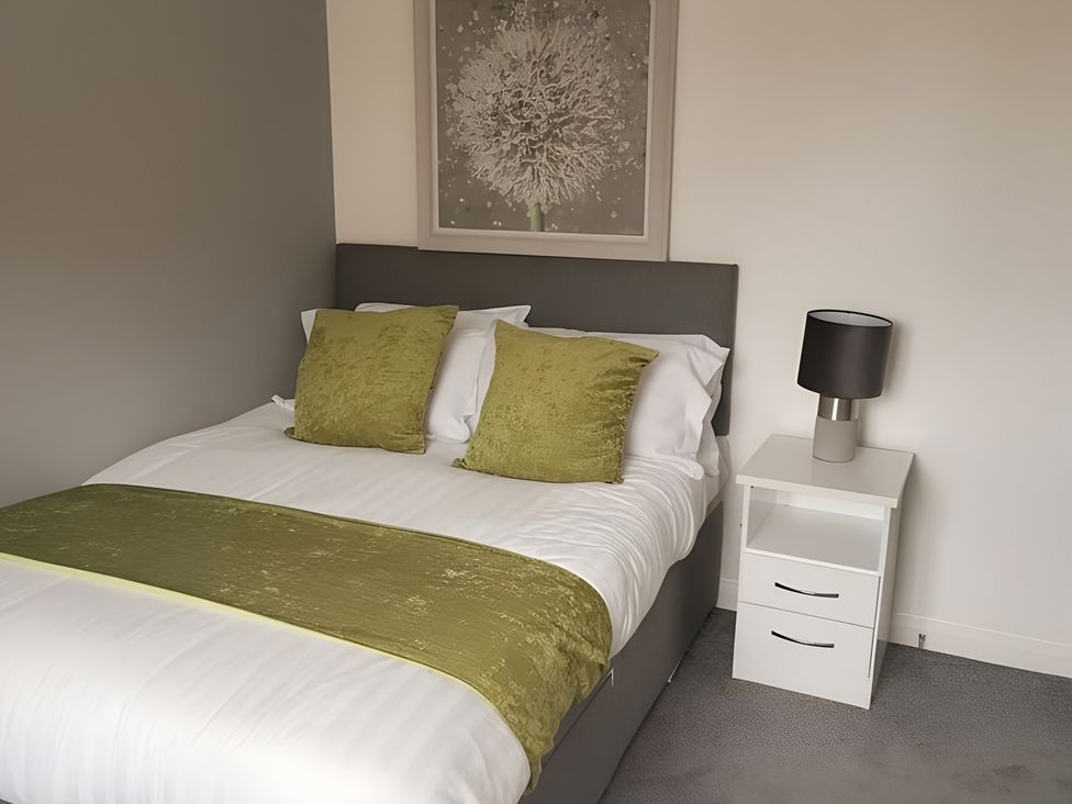 A bedroom with a bed and nightstand at the property