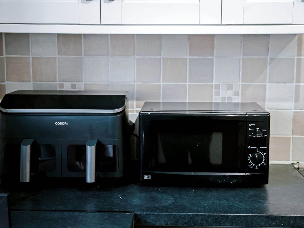 A microwave and air fryer on a countertop at the kitchen