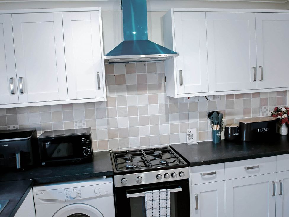 A kitchen with a gas stove and microwave at the property in undefined