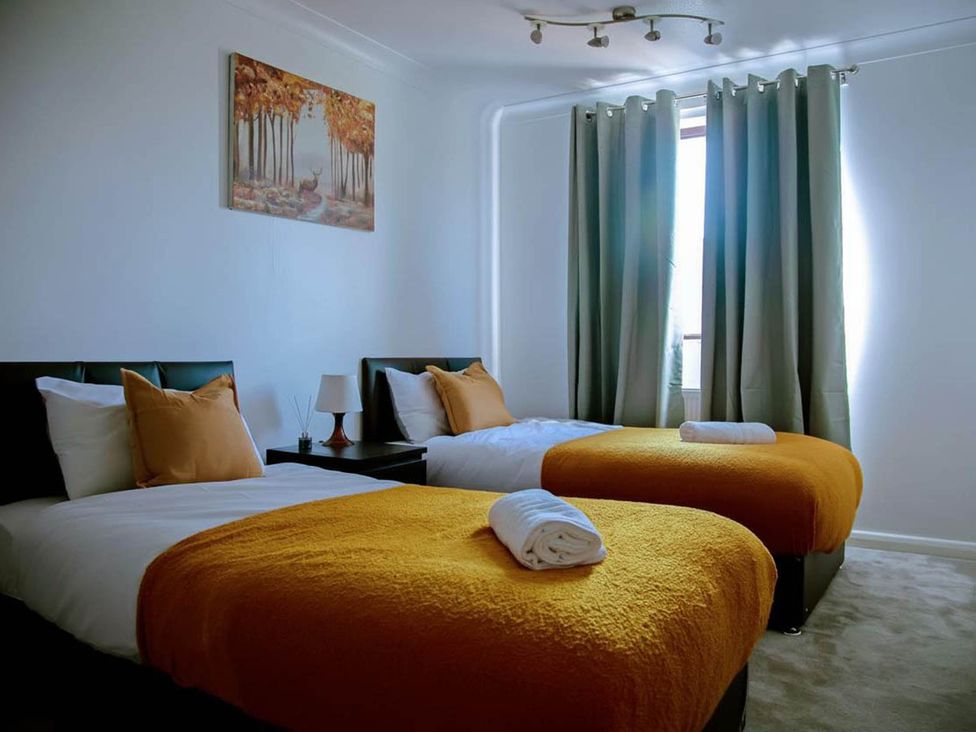 A bedroom with two beds and a lamp at The Old Barn in Manchester