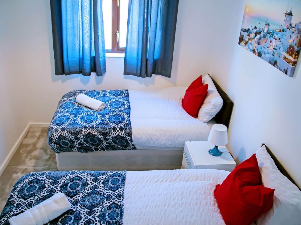 A bedroom with two beds and a nightstand at 