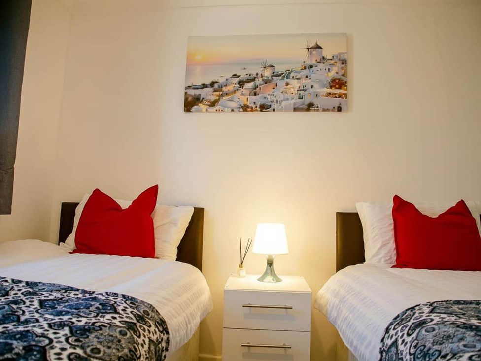 A bedroom with two beds and a bedside table at '' in ''