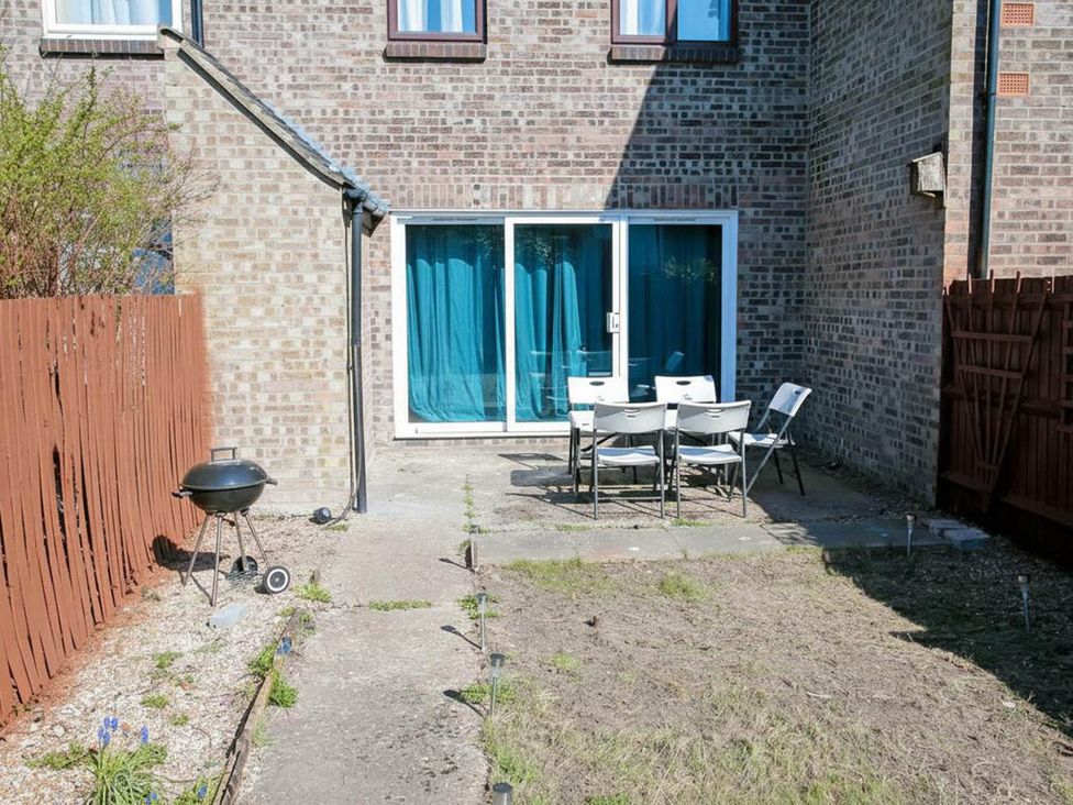 A garden with a dining set and grill at The Old Barn in Manchester