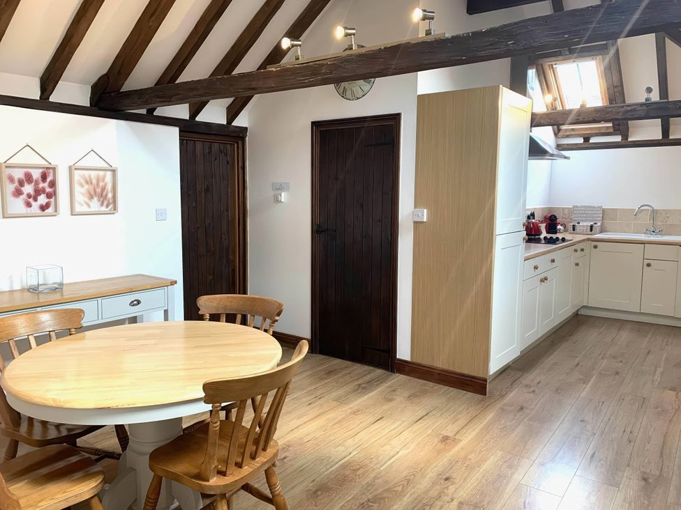 A kitchen with a table and chairs at The Old Barn in Manchester