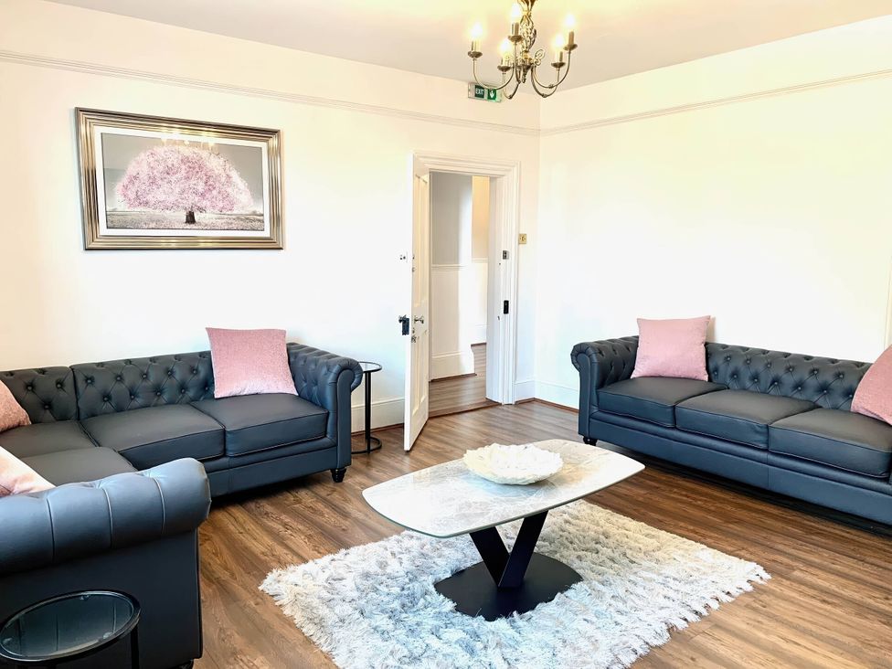 A living room with sofas, a coffee table, and a painting at the property