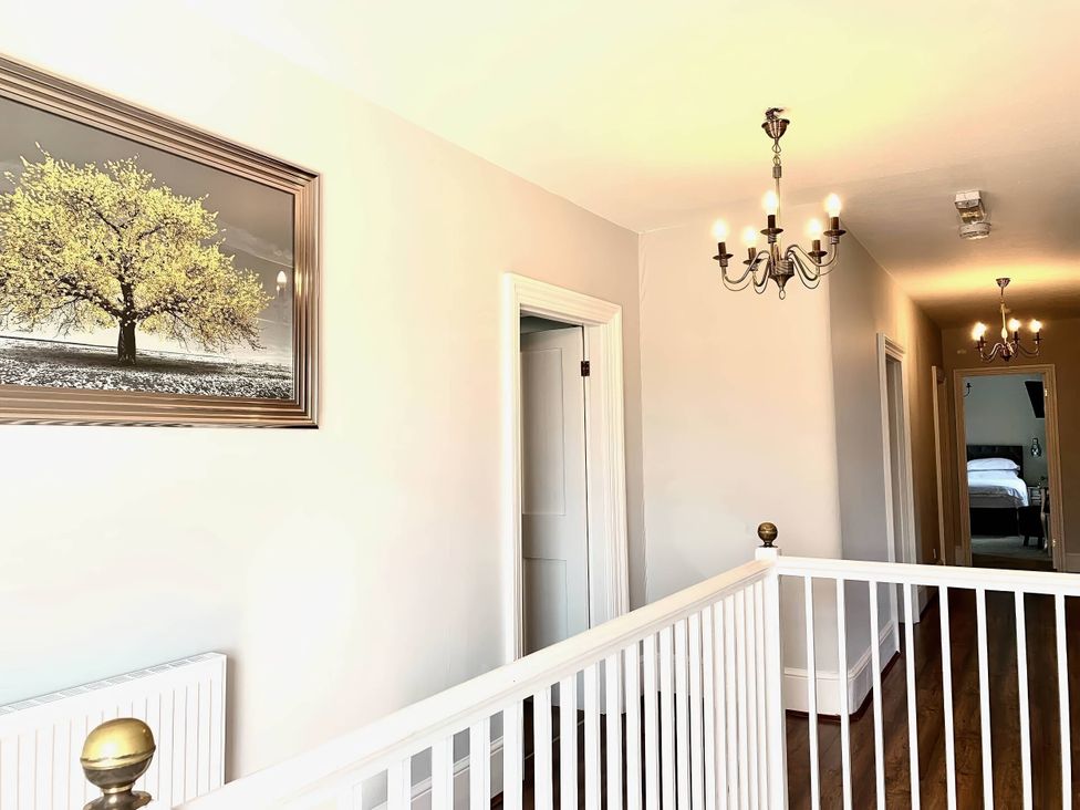 A hallway with a chandelier and a painting at The Old Barn in Manchester