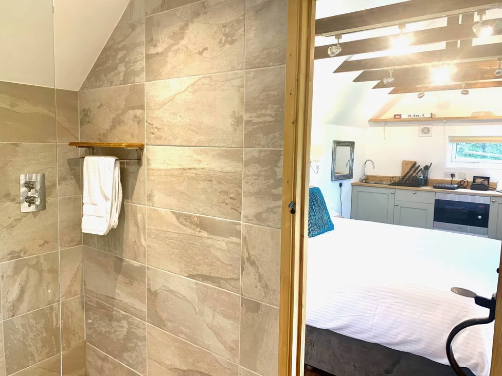 A bathroom with a towel rack and a view of a kitchen and bedroom at 