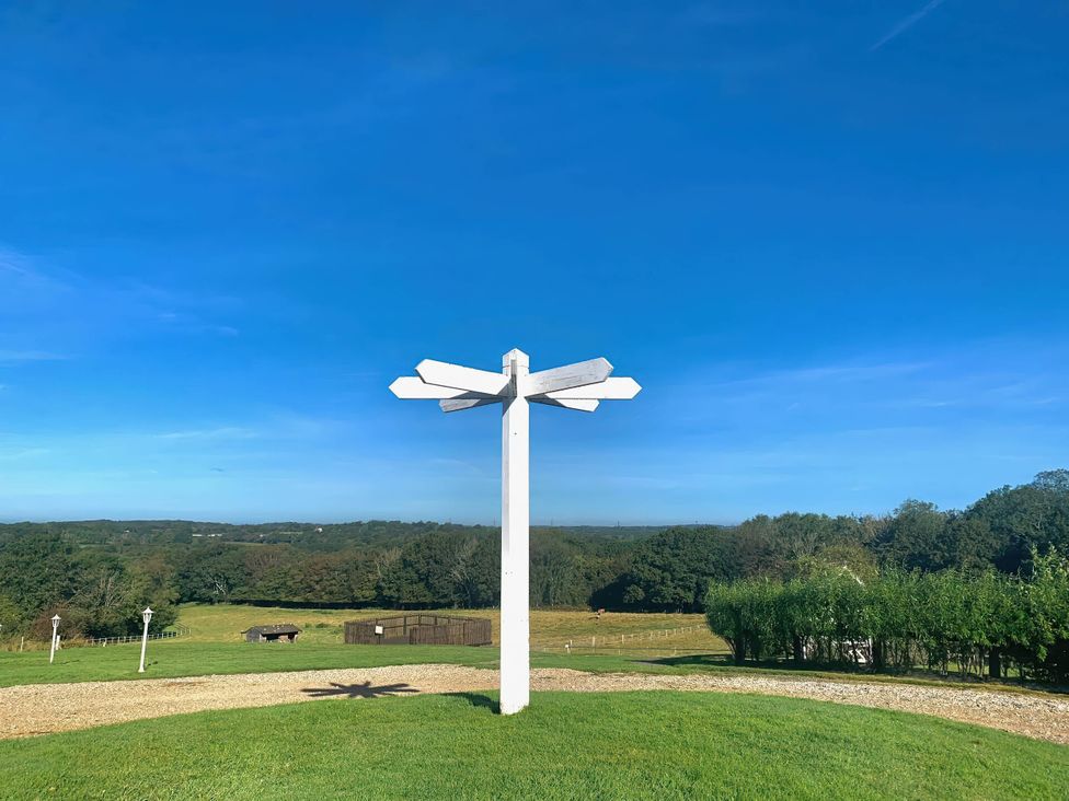 A signpost in a grassy area with blue sky at a location