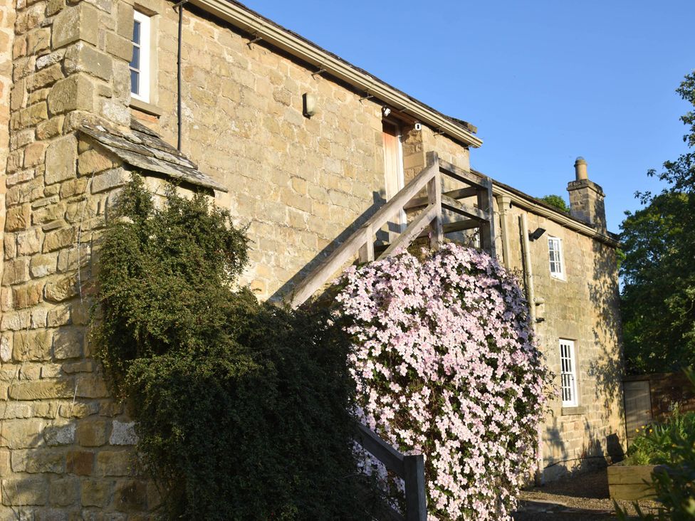 A building with stairs and flowering plants at a property