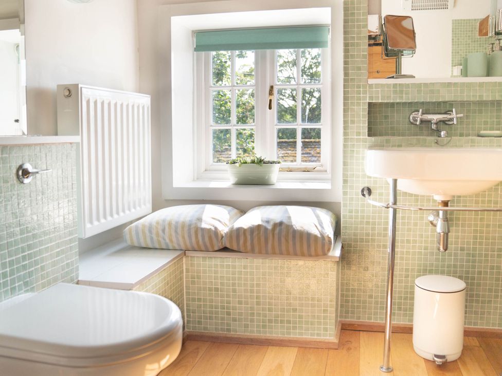 A bathroom with a sink, toilet, and window at The Old Barn in Manchester