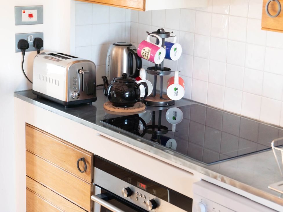A kitchen with appliances and mugs displayed at 