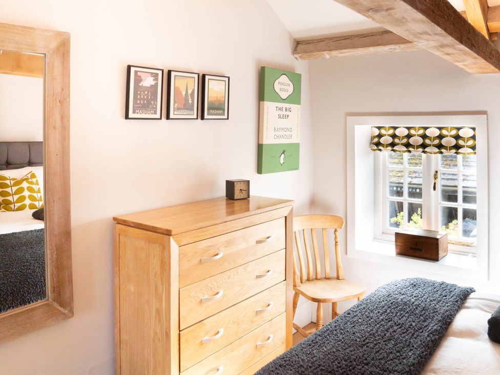 A bedroom with a chest of drawers and decorative items at 