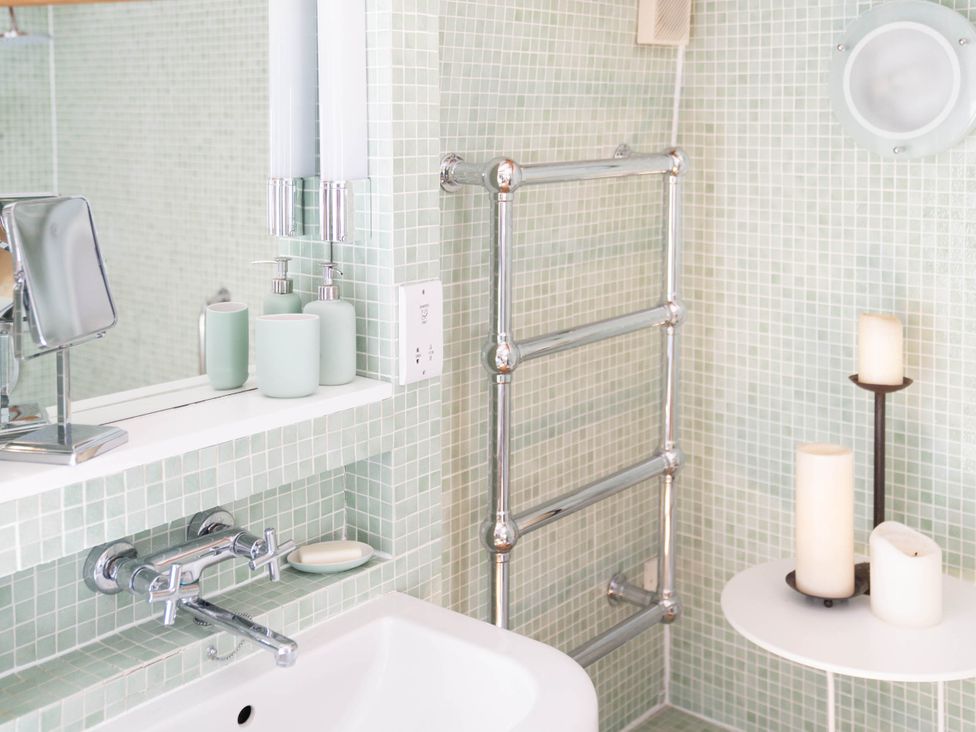 A bathroom with a sink, mirror and towel warmer at the property