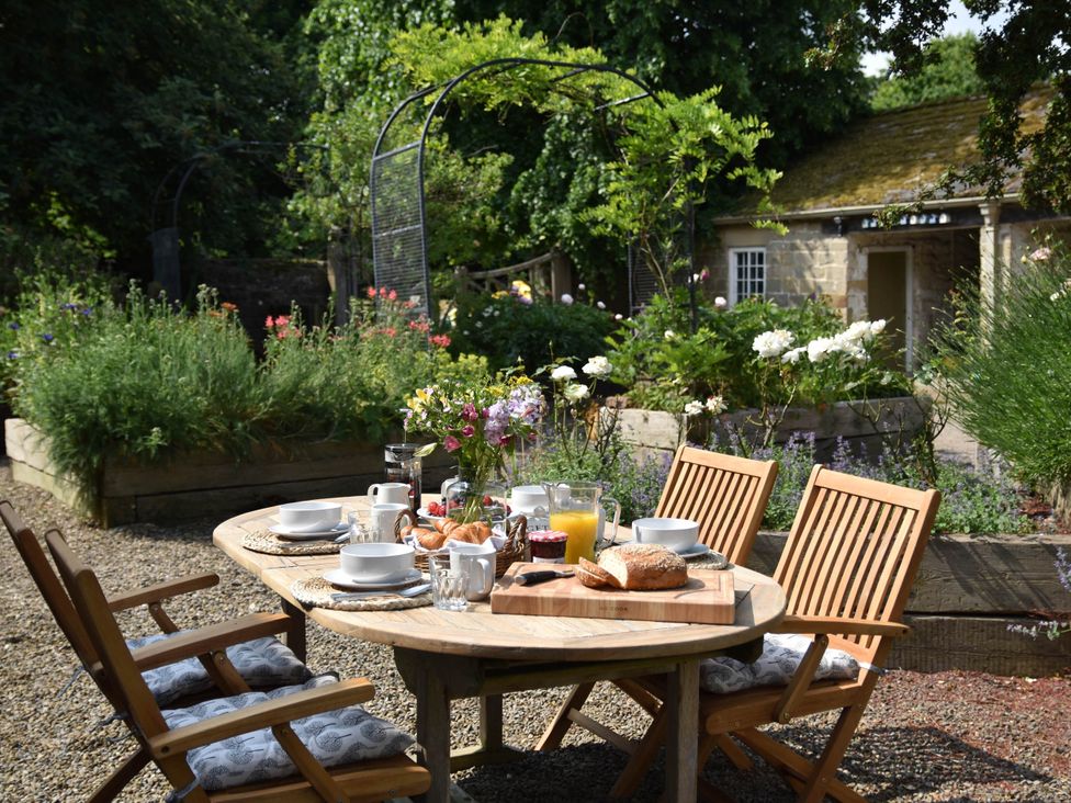A garden table set for breakfast at the property in the garden