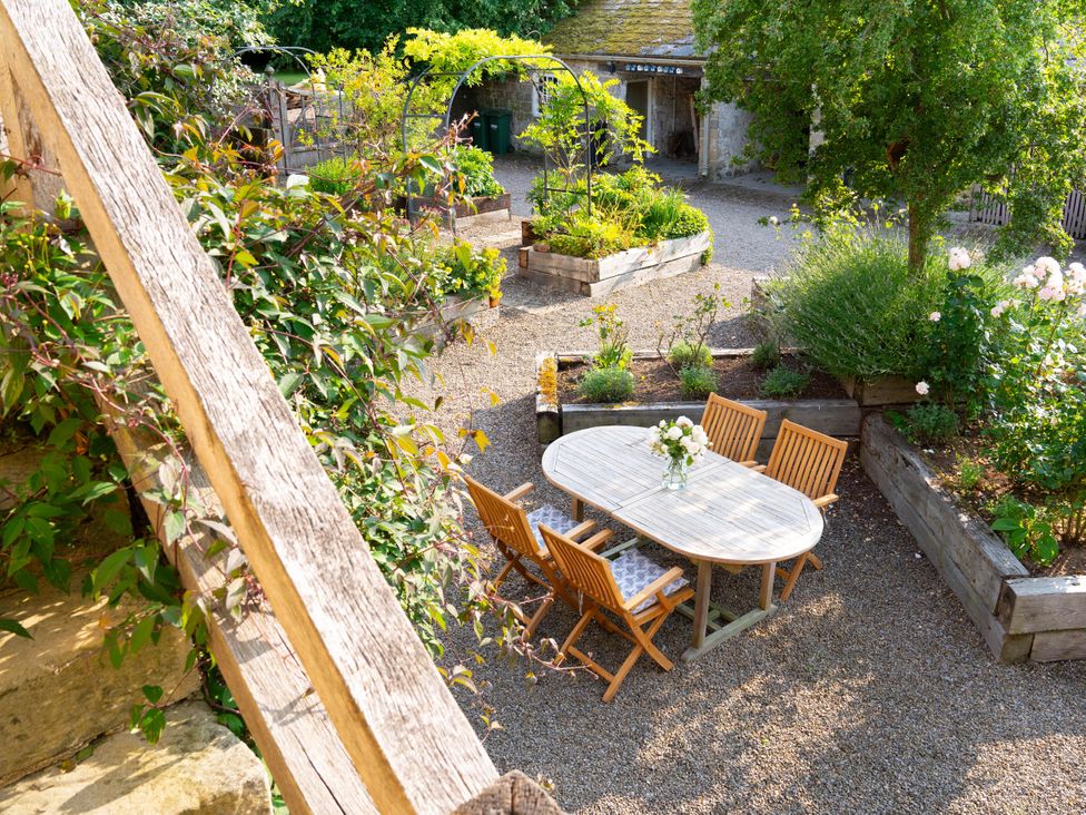 A garden with a table and chairs surrounded by flower beds at the property