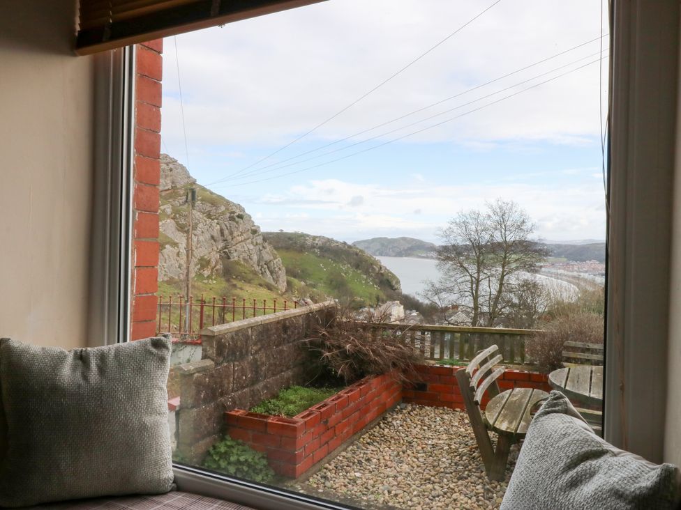 A window with a view of a garden and mountain at 3 Bay View Terrace in Llandegfan