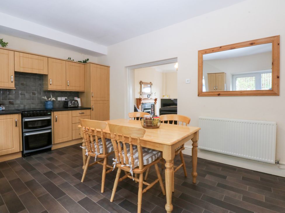 A kitchen with wooden furniture and appliances at 3 Bay View Terrace in Llandegfan