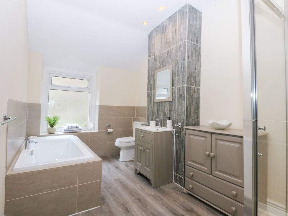 A bathroom with a bathtub and shower at 3 Bay View Terrace in Llandegfan
