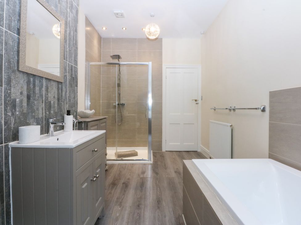 A bathroom with a bath tub and a shower at 3 Bay View Terrace in Llandegfan