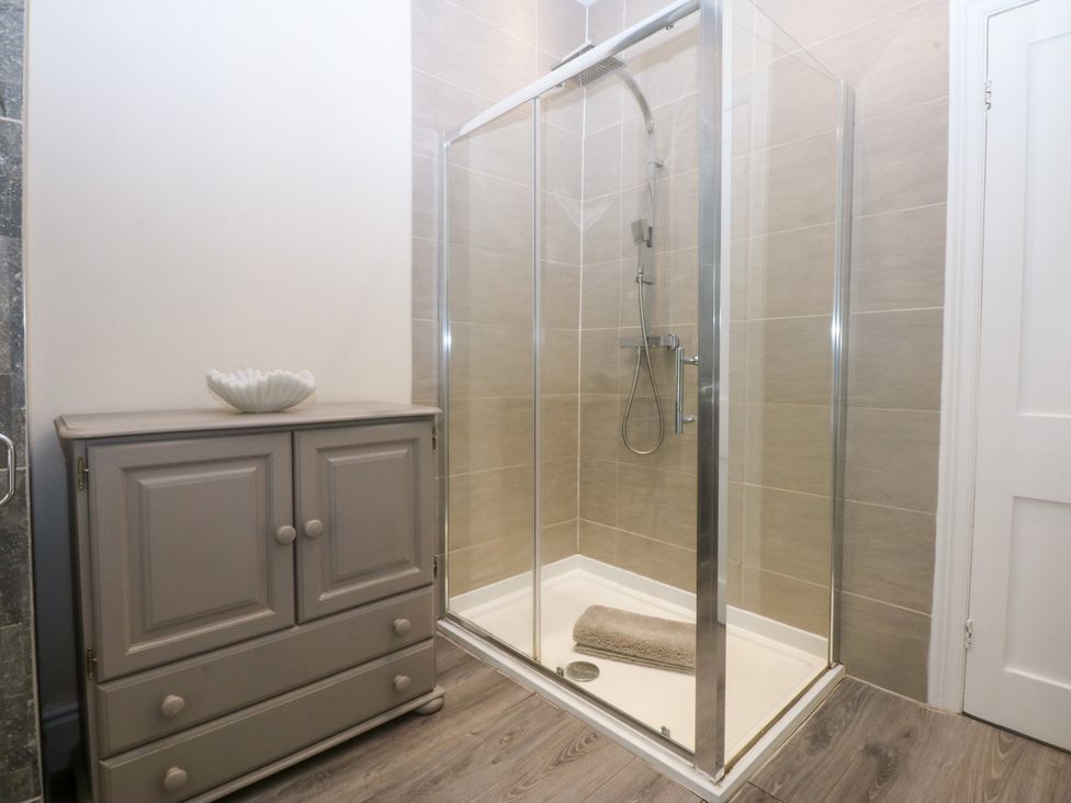 A bathroom with a shower and cabinet at 3 Bay View Terrace in Llandegfan
