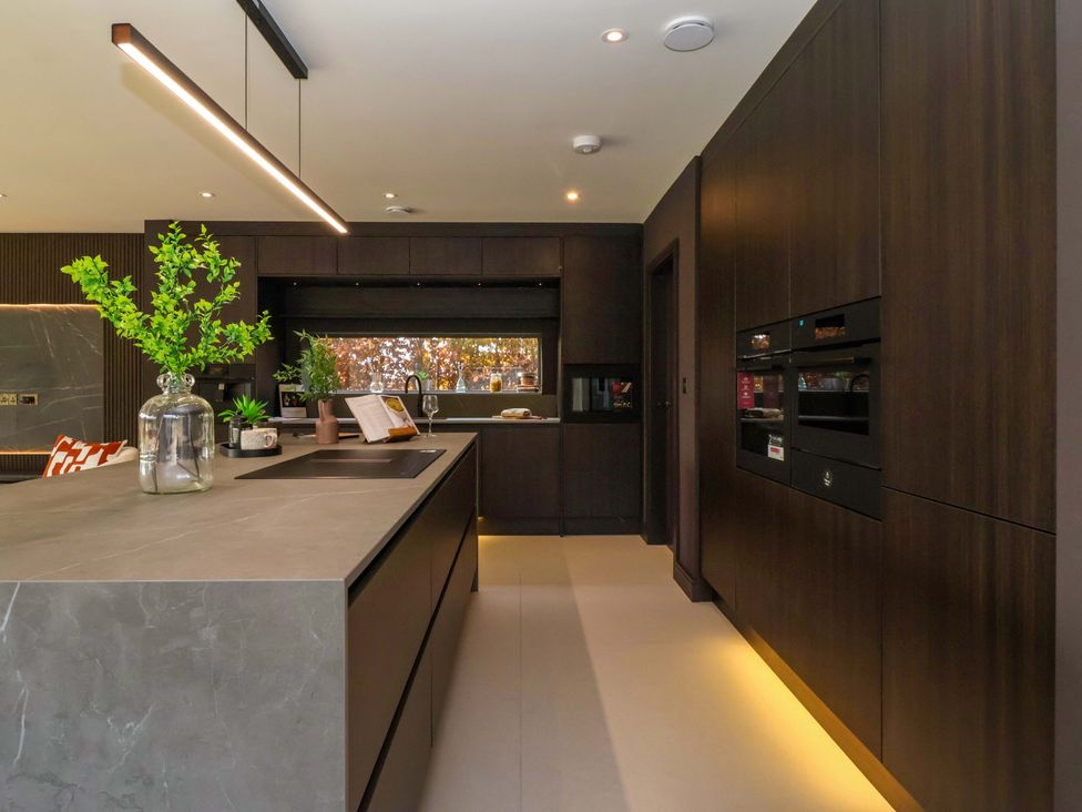 A kitchen with a central island and dark cabinetry at Woldside in York