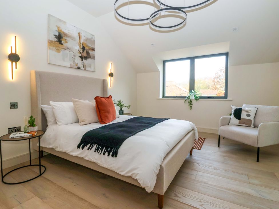 A bedroom with a bed, chair and window at Woldside in York