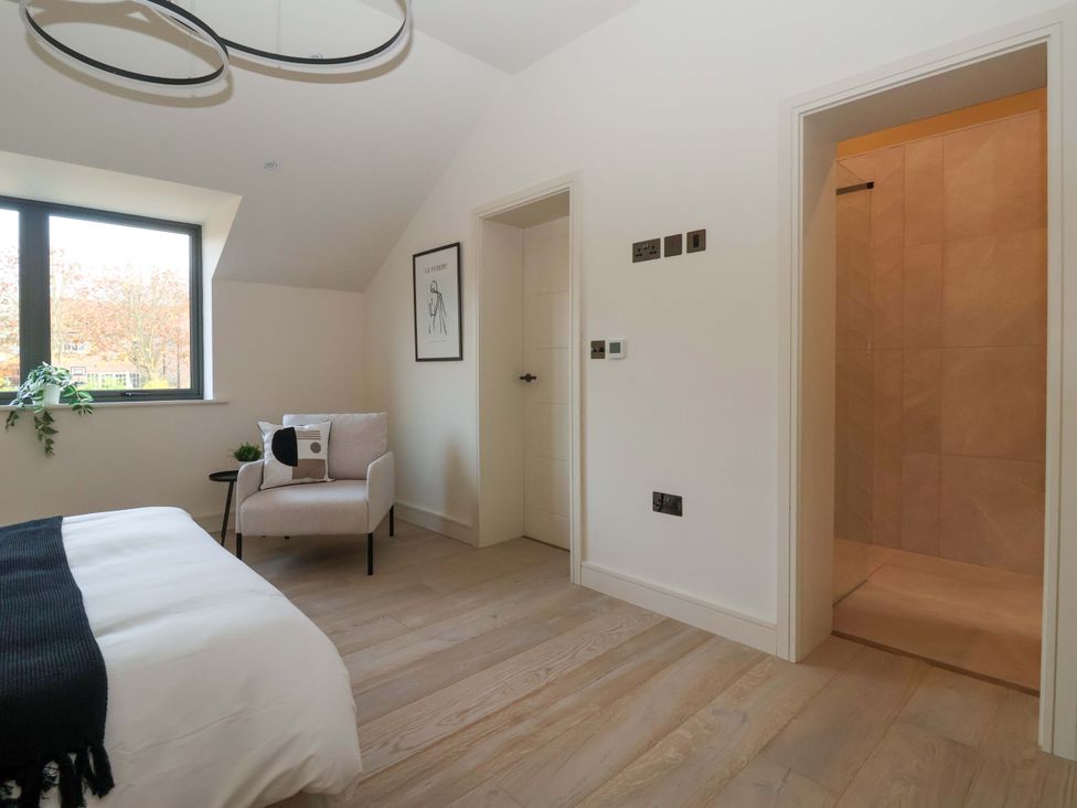 A bedroom with a bed and an en-suite shower at Woldside in York