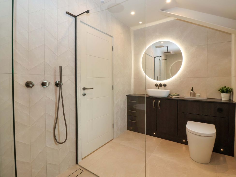 A bathroom with a shower, toilet, and sink at Woldside in York