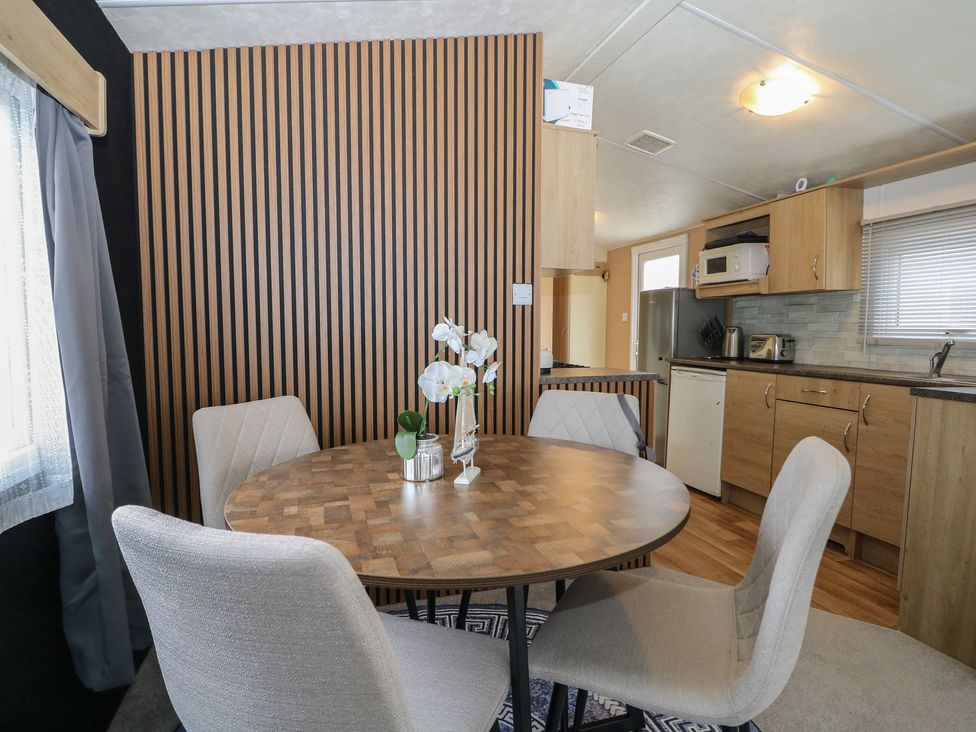 A dining area with a round table and chairs at 90 Solent Breezes Southampton