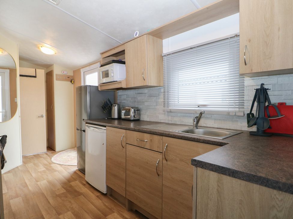 A kitchen with appliances and cabinets at 90 Solent Breezes in Southampton