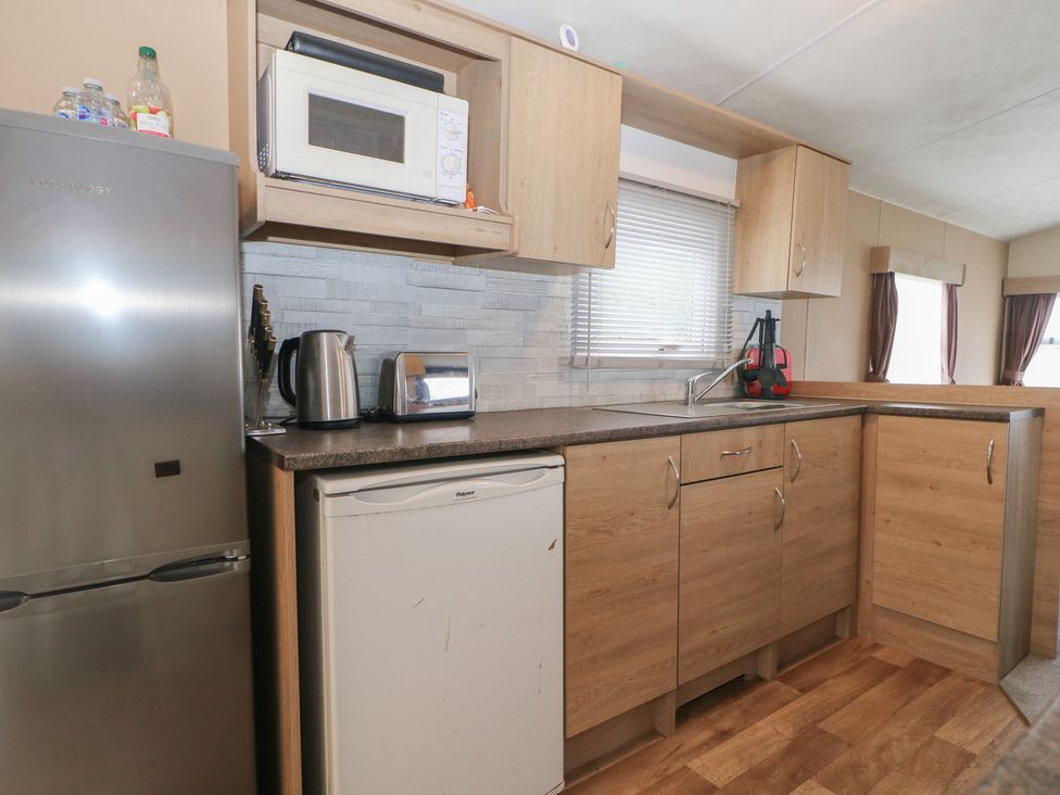 A kitchen with appliances and cabinets at 90 Solent Breezes in Southampton