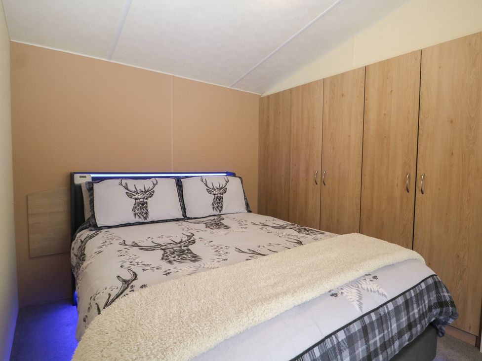 A bedroom with a bed and wardrobe at 90 Solent Breezes in Southampton