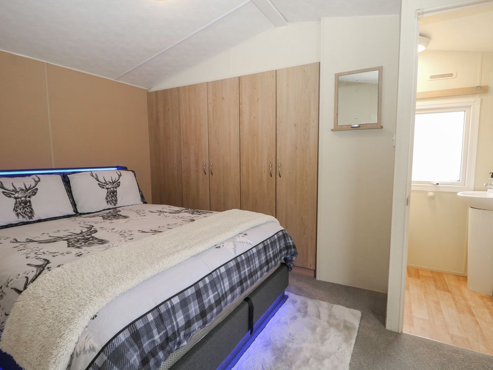 A bedroom with a bed and wardrobe at 90 Solent Breezes in Southampton