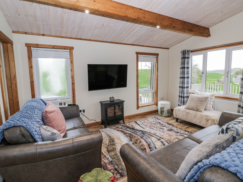 A living room with a television and sofa at Willow Lodge in Admaston near Abbots Bromley